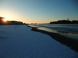 雪の江ノ島片瀬海岸西浜から朝日