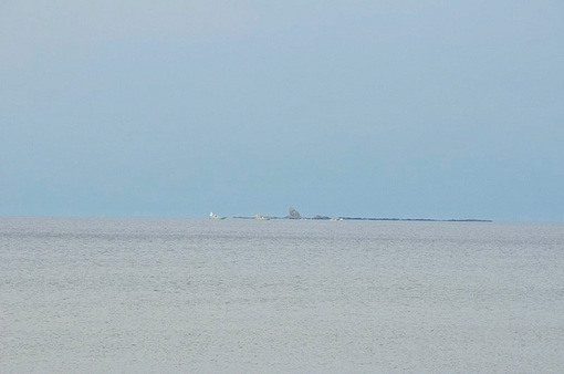 湘南海岸から海を眺めた烏帽子岩とサーファー