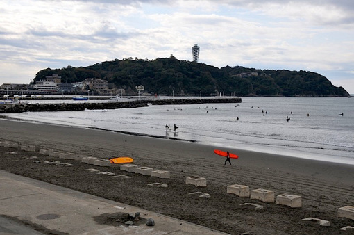 江ノ島片瀬海岸西浜で曇り空の下のサーファー
